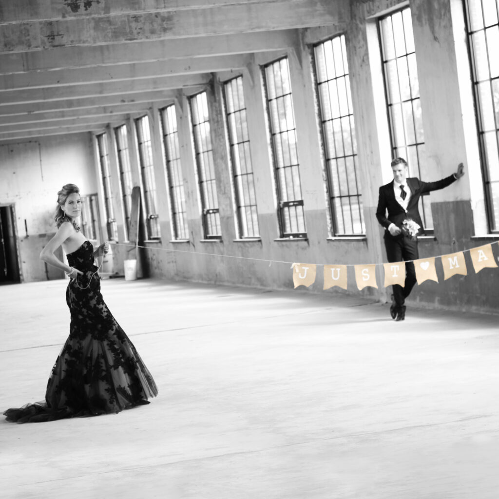 Bruidspaar in een grote lege fabriekshal, trouwfotografie op locatie