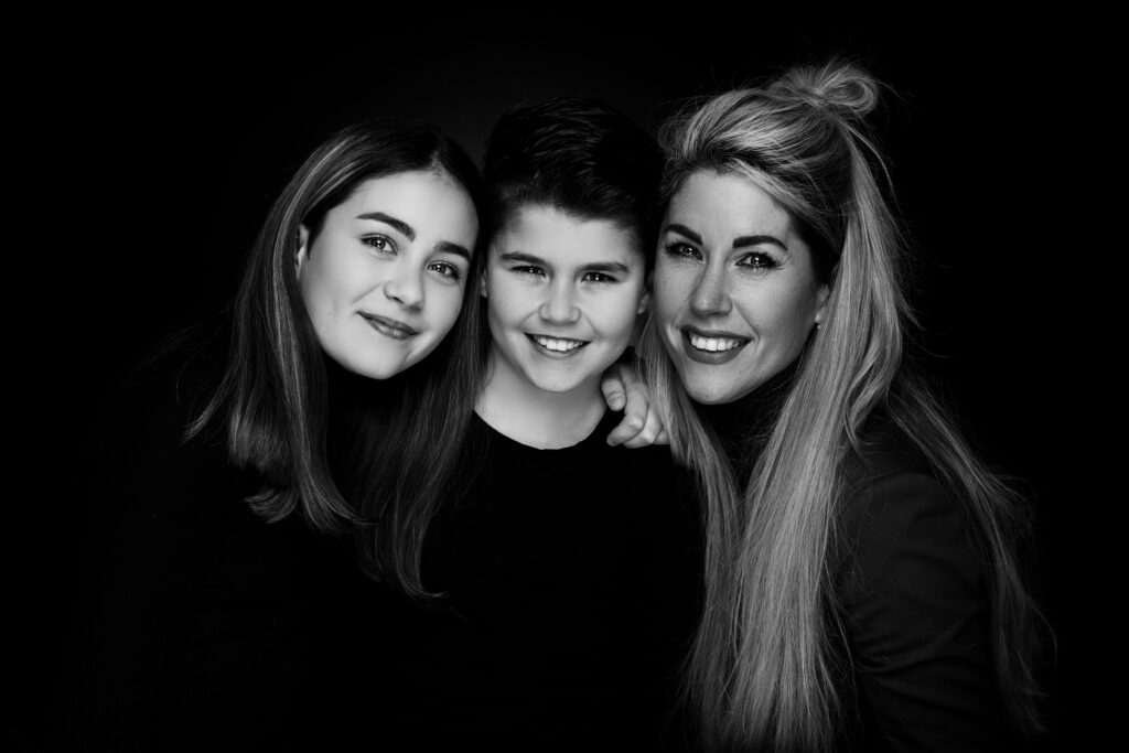 Drie broers en zussen samen tegen een zwarte achtergrond, Pure Portrait