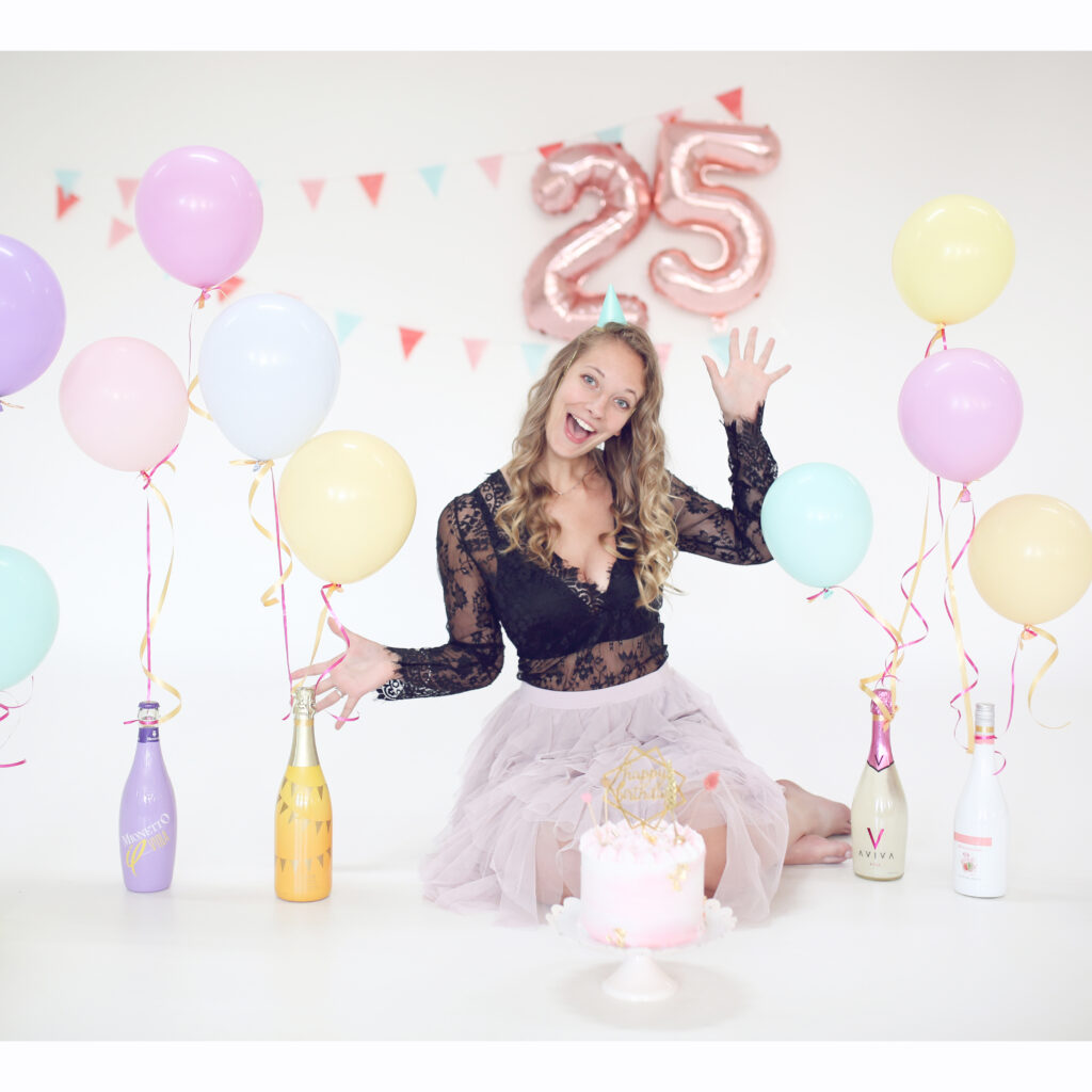 Vrouw met ballonnen en een 25-ballon tijdens een verjaardagsfotoshoot in de studio