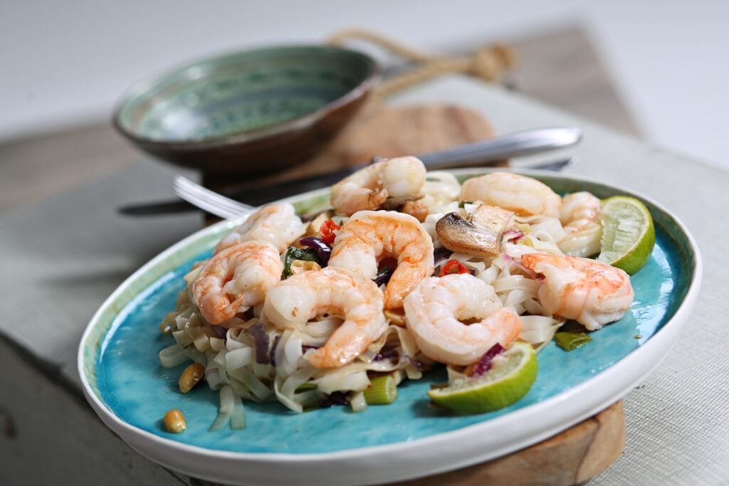 Garnalen met limoen op een blauw bord, foodfotografie voor een restaurant
