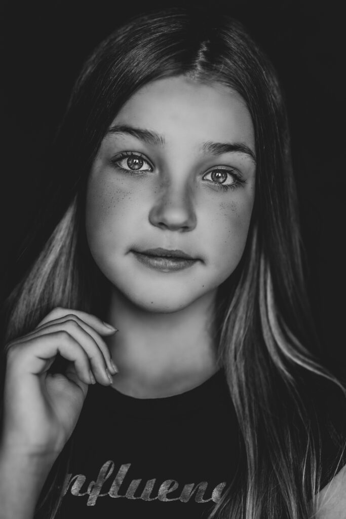 Zwart-witportret van een meisje met de hand bij haar gezicht