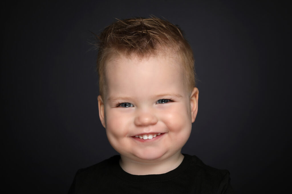 Lachend jongetje tegen een donkere achtergrond, Pure Portrait