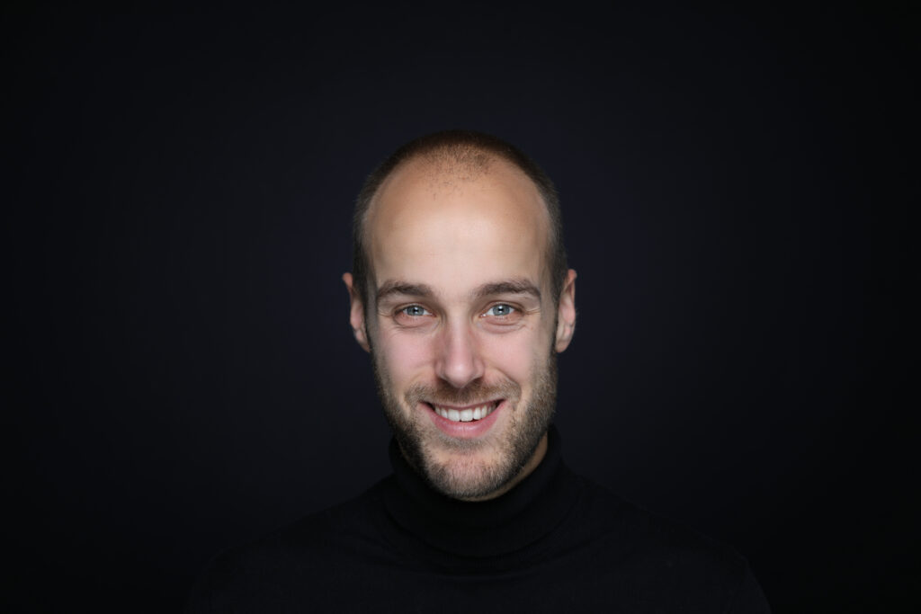 Portret van een lachende man in zwart, Pure Portrait