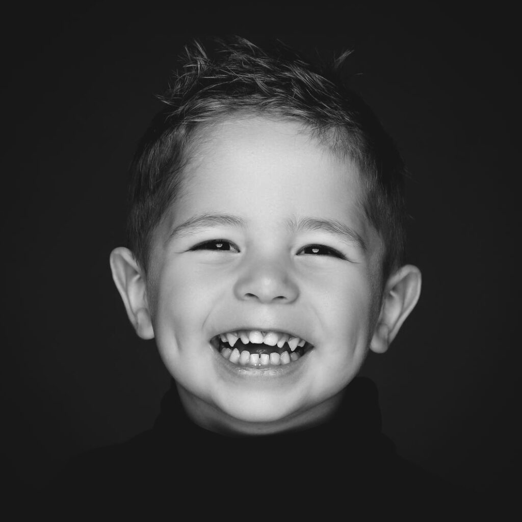 Zwart-witportret van een schaterende jongen, Pure Portrait