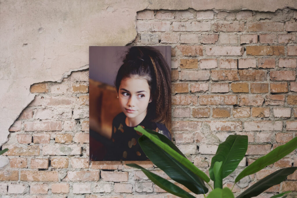 Portret van een meisje op een plaat tegen een bakstenen muur, wanddecoratie