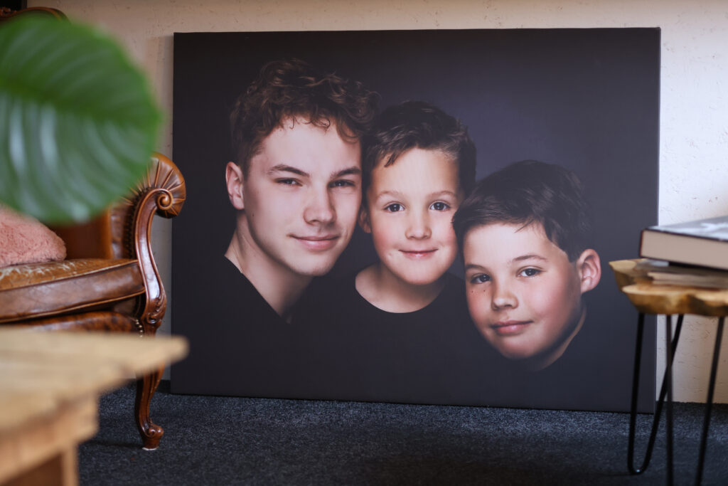 Portret van drie broers op een plaat tegen een donkere achtergrond