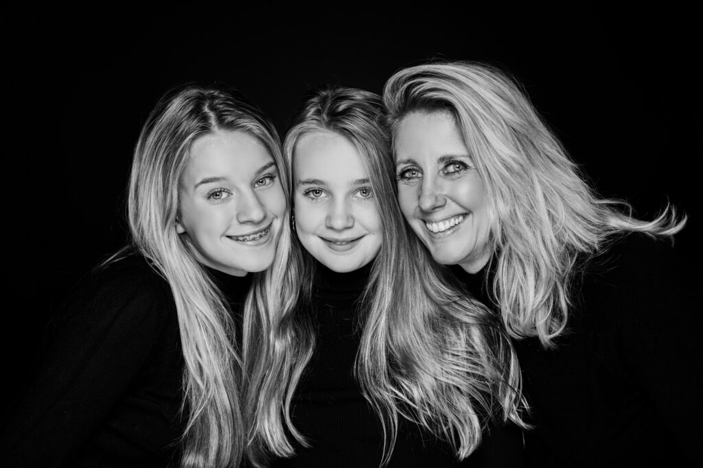 Zwart-witportret van moeder en twee dochters met lang haar