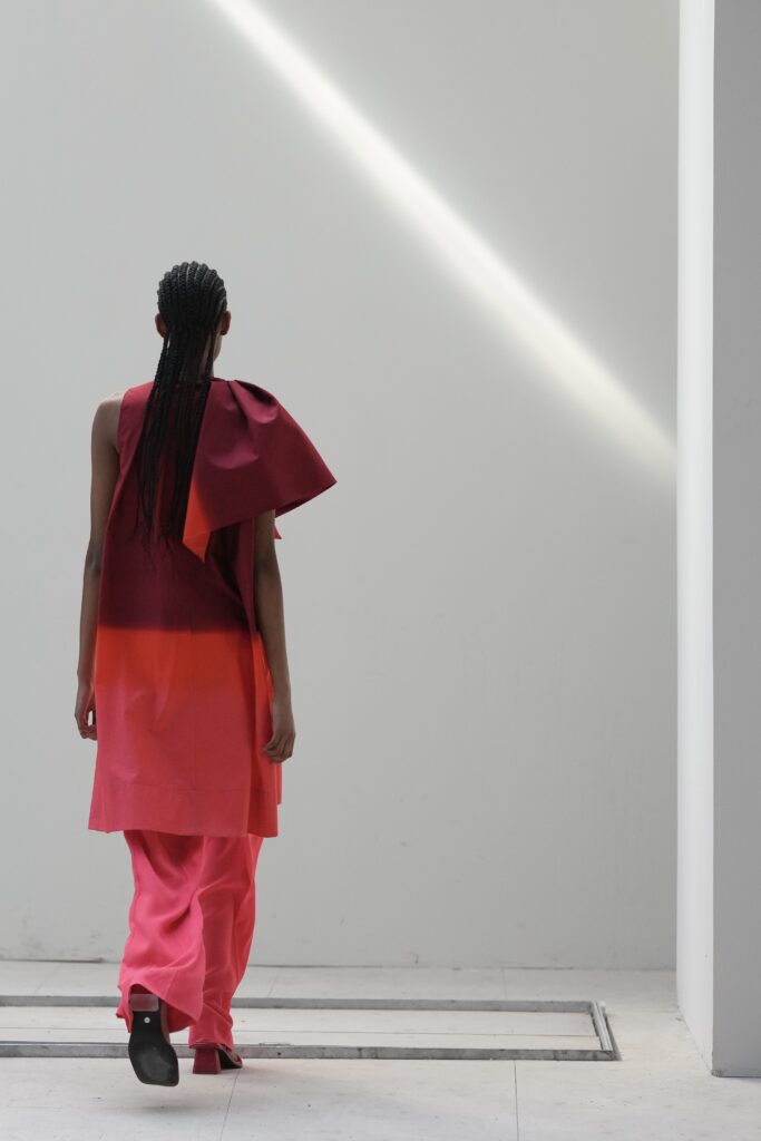 Achterkant van een model in roze outfit met grote strik