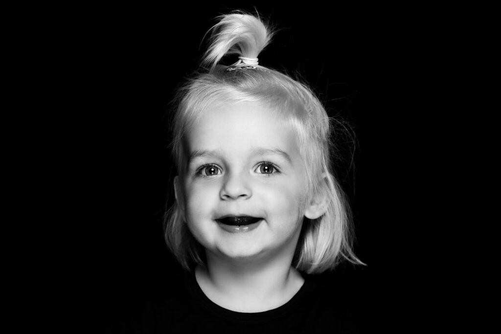 Zwart-witportret van een peuter met staartje