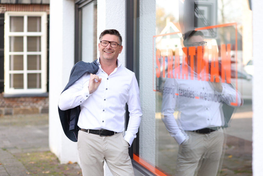 Zakelijk portret van een man in wit overhemd voor een winkelpand