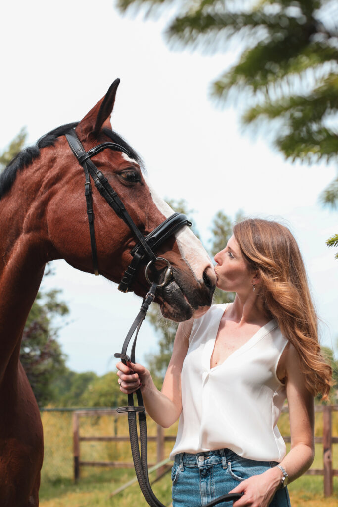 Vrouw geeft haar bruine paard een kus, paardenfotografie
