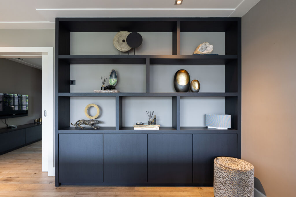 Zwarte wandkast met decoratie en open vakken, interieurfotografie