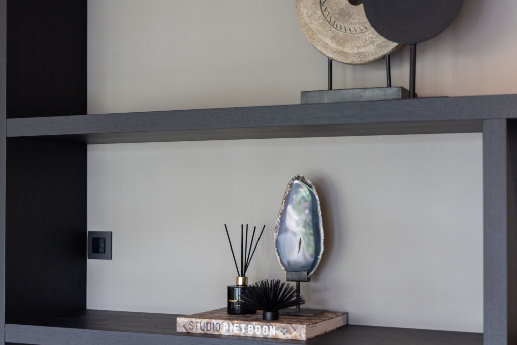 Zwarte wandplanken met geurstokjes en decoratie