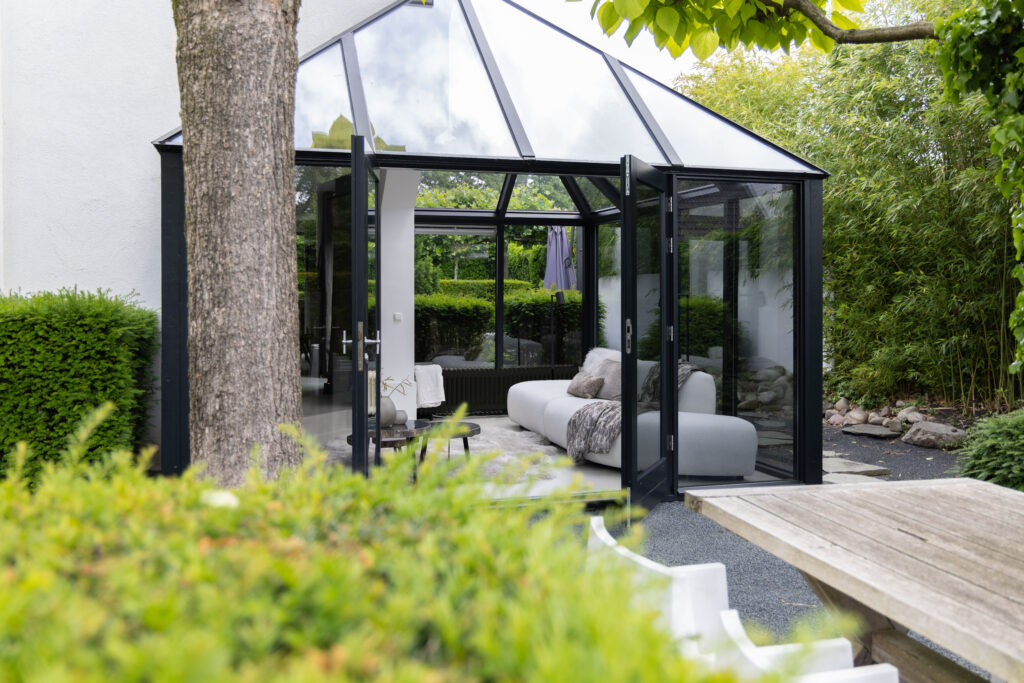 Glazen tuinkamer in een groene achtertuin, vastgoedfotografie