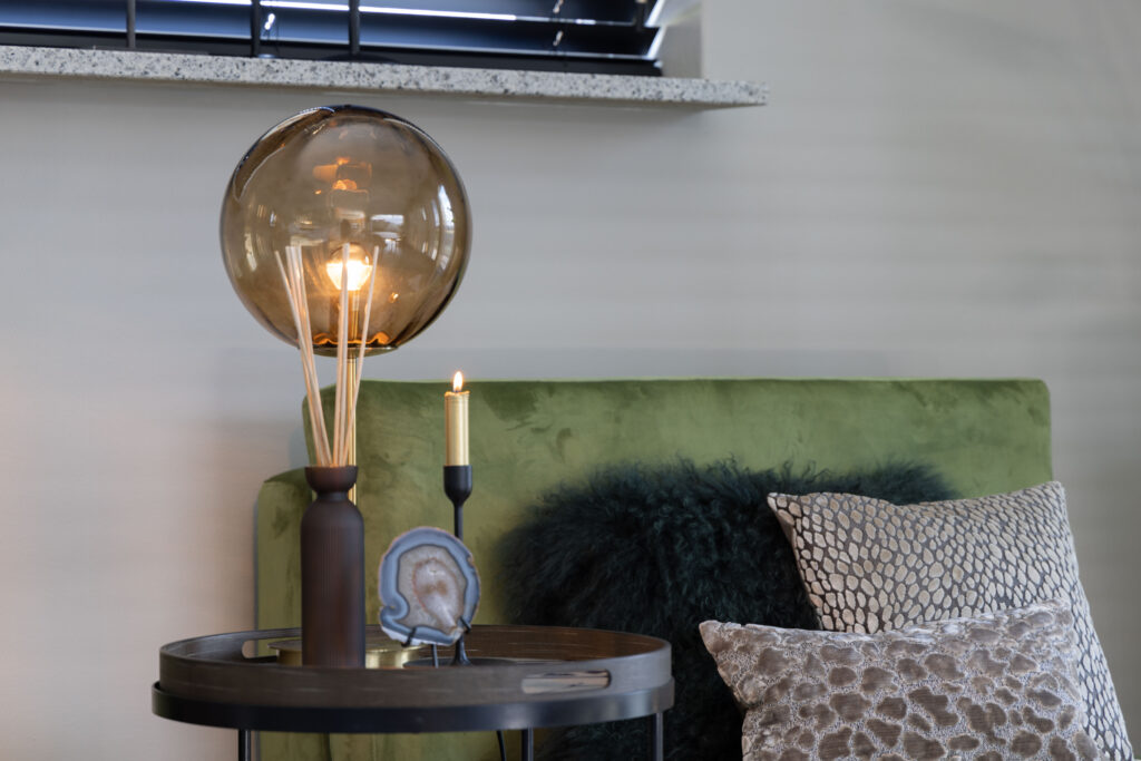 Gouden bollamp en kaarsen bij een groene bank, sfeerfoto