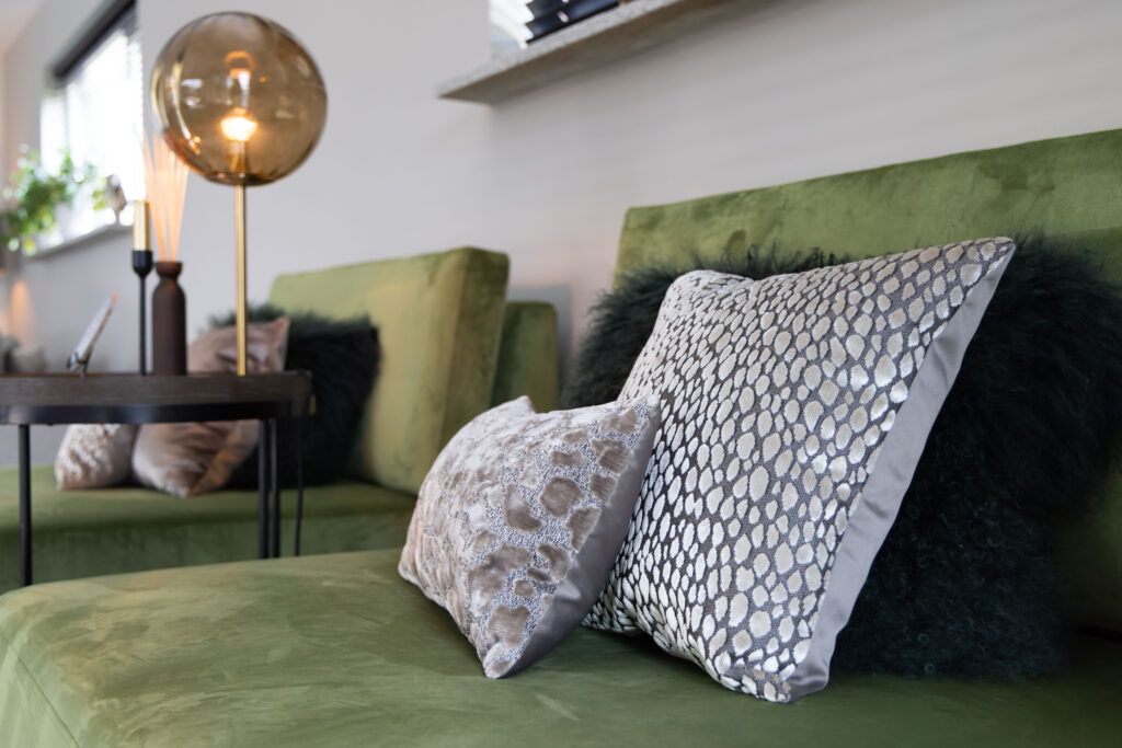 Groene fluwelen bank met kussens en gouden lamp, sfeerfoto woonkamer