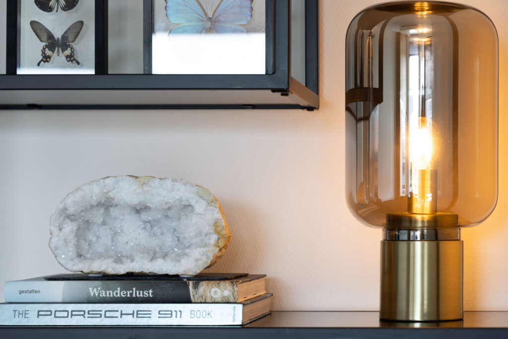 Gouden lamp met boeken en kristal op een dressoir, interieurdetail