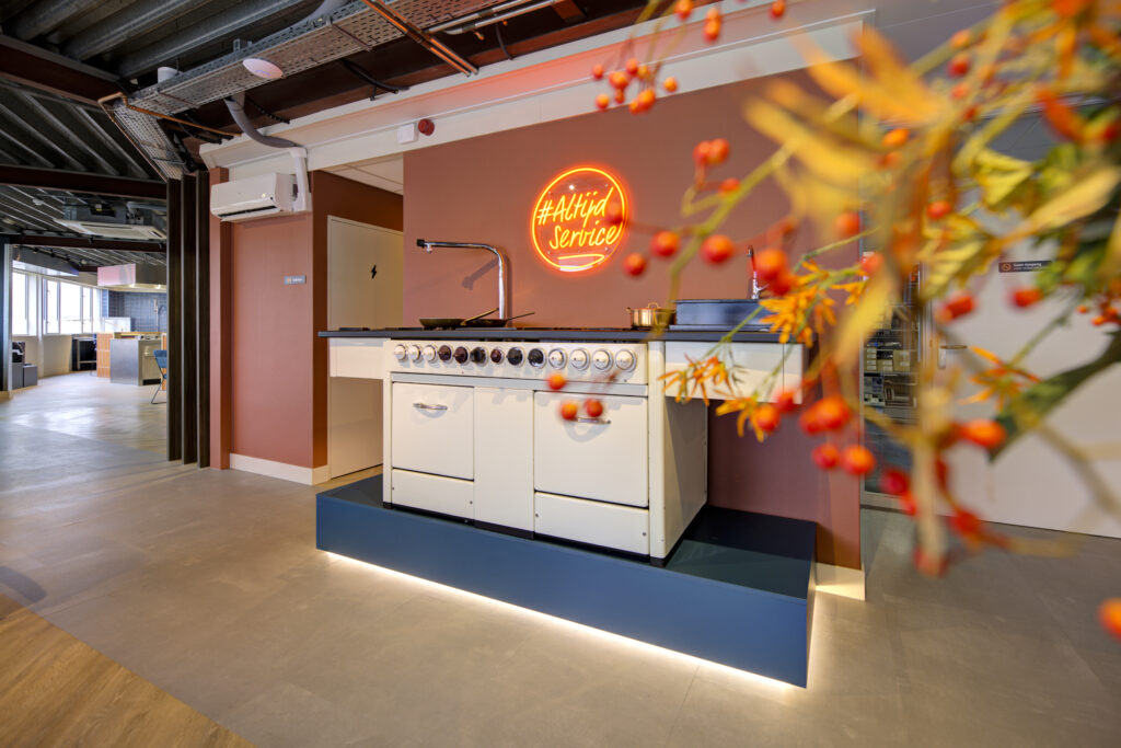 Showroomkeuken met oranje accenten en bloemen, bedrijfsreportage interieur