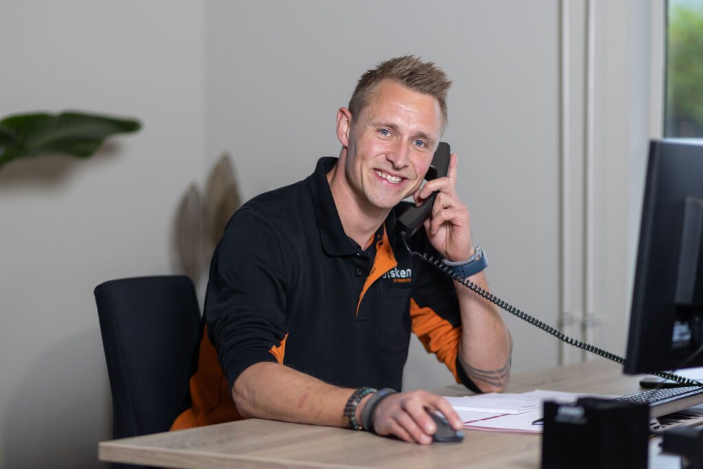 Zakelijke sfeerimpressie van een medewerker aan de telefoon op kantoor in Twente