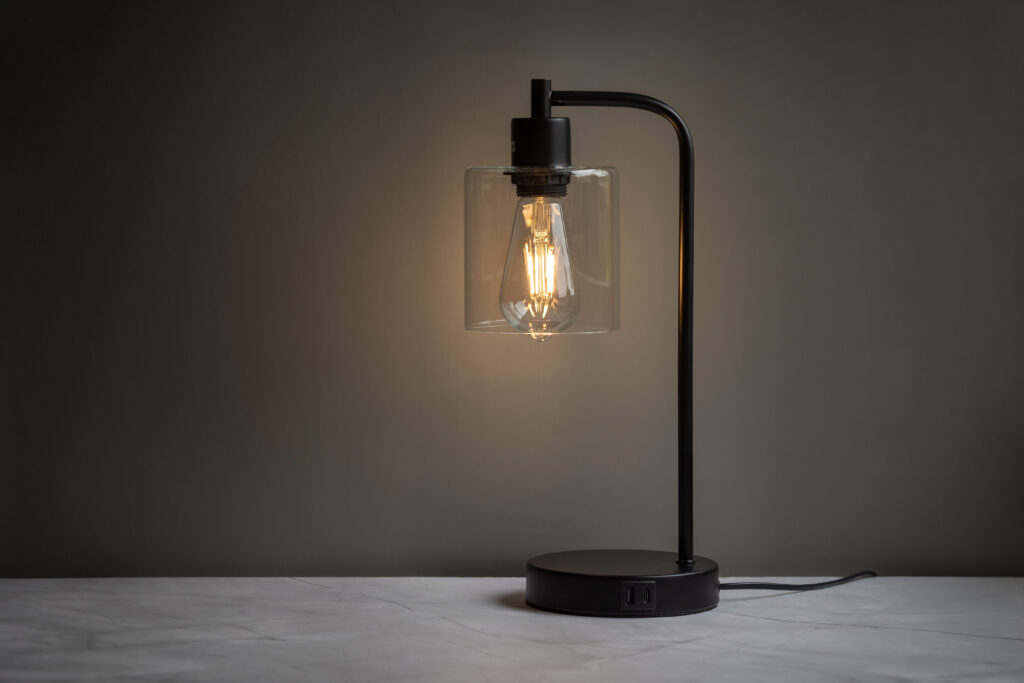 Zwarte tafellamp met gloeilamp in een donkere ruimte, sfeerproductfoto