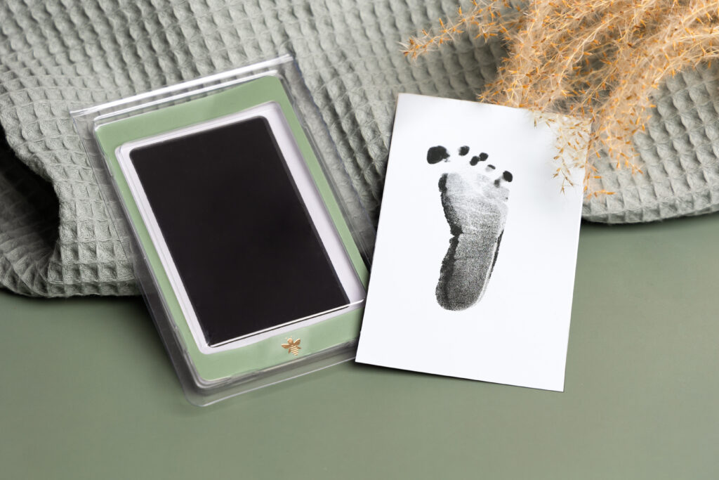 Babyvoetafdruk en inktkussen op een gebreide doek, productfoto