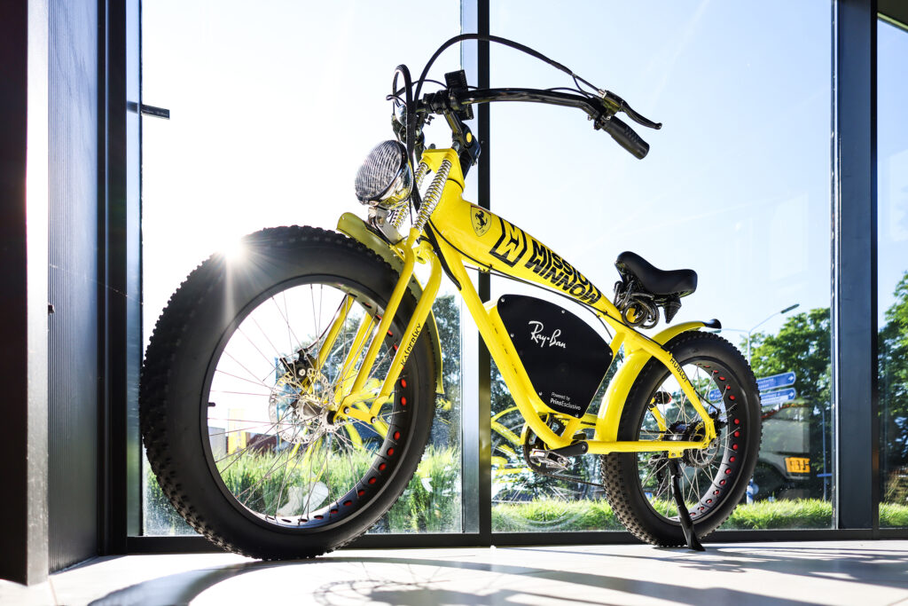 Gele elektrische fatbike voor een glazen pui, productfoto op locatie