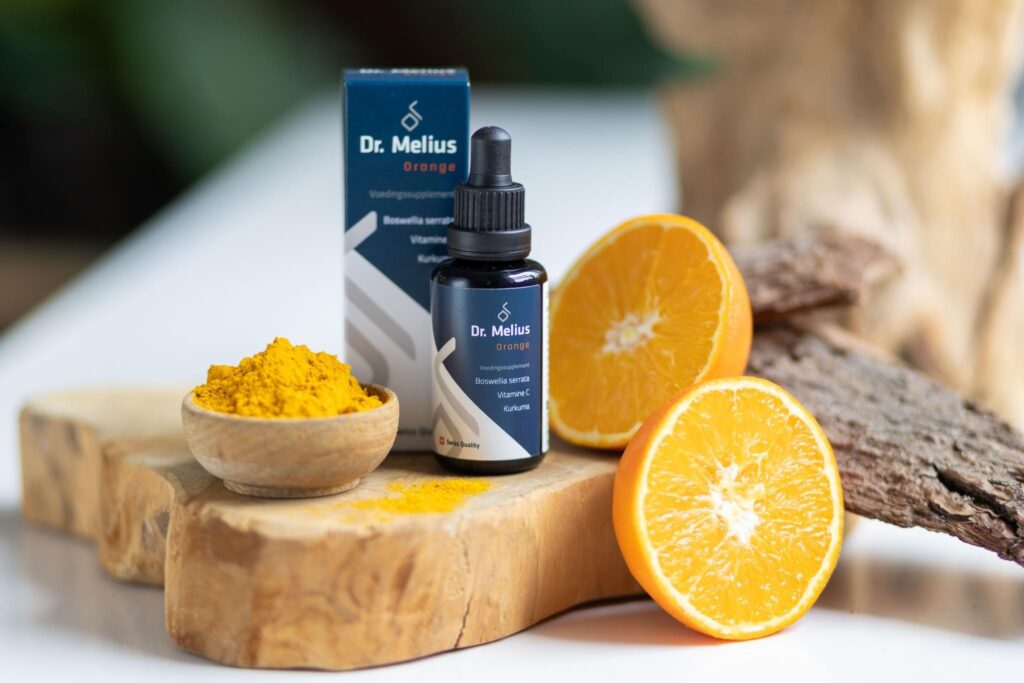 Flesje supplement met sinaasappels en kurkuma op hout, productfoto in sfeer