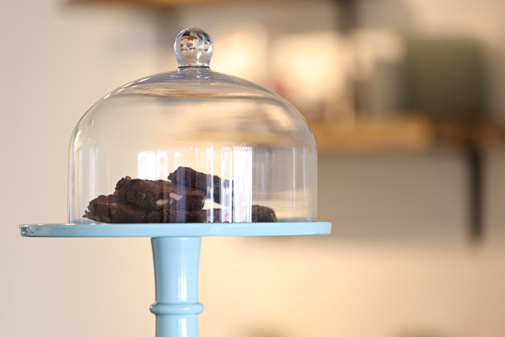 Glazen taartstolp op een blauwe standaard, productfoto