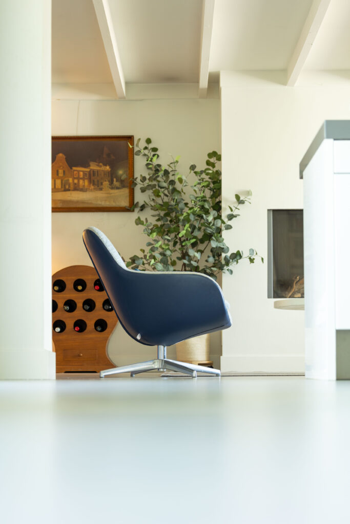 Designstoel in een lichte ruimte met wijnrek, interieurfotografie